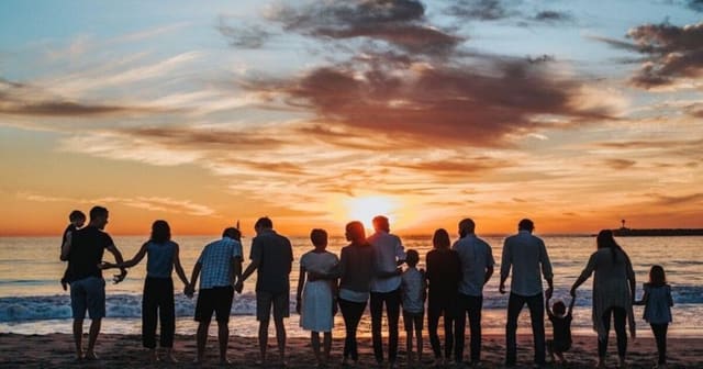 Mehrgenerationenfamilie beim gemeinsamen Spaziergang im Park, Eltern mit Kindern und Großeltern